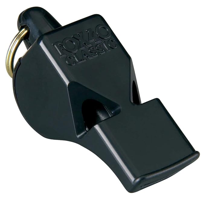 Fox 40 Classic Whistle on a sports field: "The iconic Fox 40 Classic Whistle resting on the sidelines of a sports field, ready for action. Now on Probadminton.in