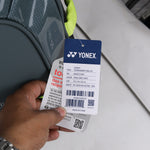 Yonex badminton racket with a tag held by a hand on a light background